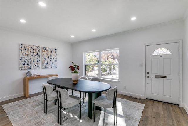 dining space featuring hardwood / wood-style flooring and crown molding