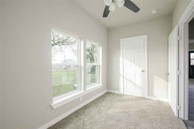 spare room with ceiling fan, a healthy amount of sunlight, and carpet