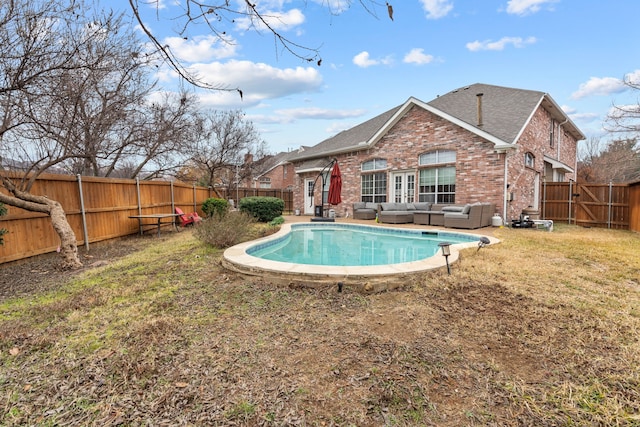 view of pool with outdoor lounge area and a yard