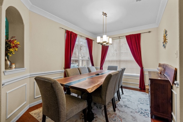 dining space with hardwood / wood-style floors, crown molding, and a notable chandelier