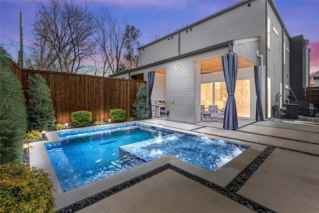 pool at dusk featuring a patio area