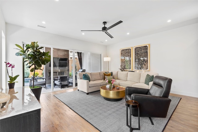 living room featuring light hardwood / wood-style floors and ceiling fan