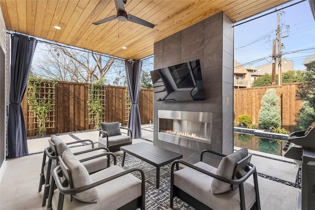 view of patio / terrace with an outdoor living space with a fireplace and ceiling fan