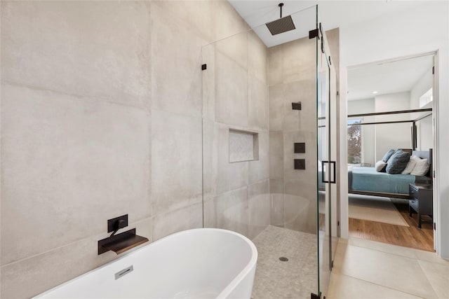 bathroom with plus walk in shower, tile patterned flooring, and tile walls