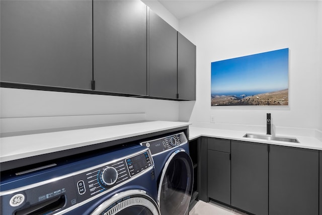 laundry room with cabinets, washing machine and clothes dryer, and sink