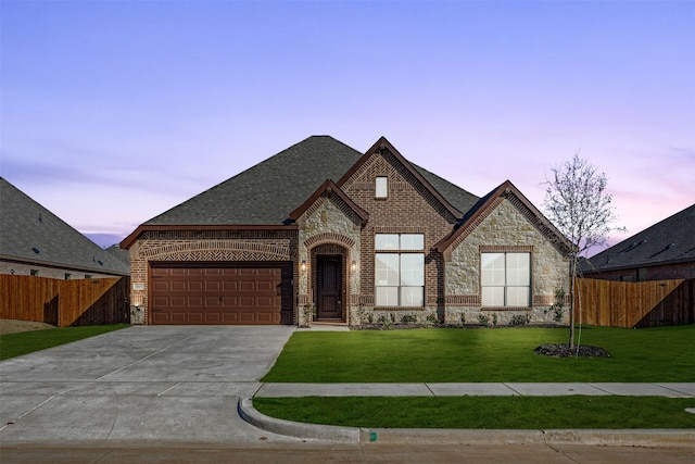 view of front of house featuring a garage and a yard