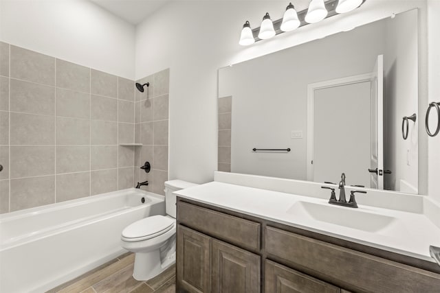 full bathroom featuring tiled shower / bath, hardwood / wood-style floors, vanity, and toilet