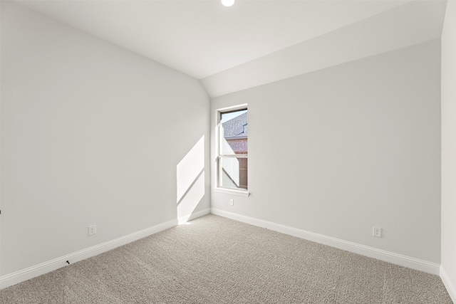 carpeted spare room with lofted ceiling