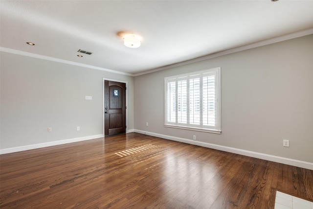 empty room with hardwood / wood-style flooring and crown molding