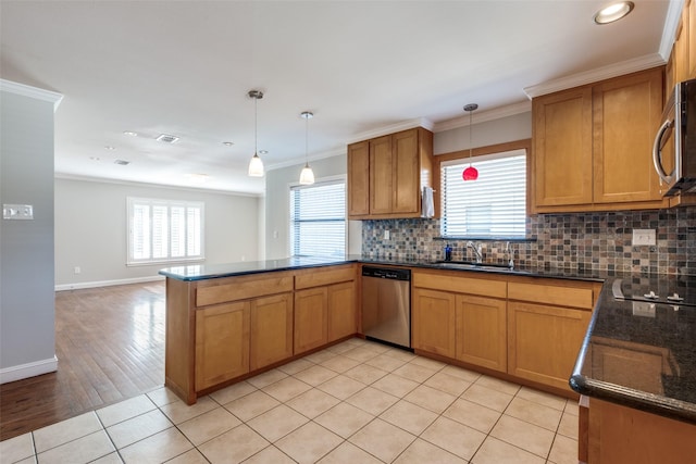 kitchen with appliances with stainless steel finishes, sink, hanging light fixtures, light tile patterned floors, and crown molding