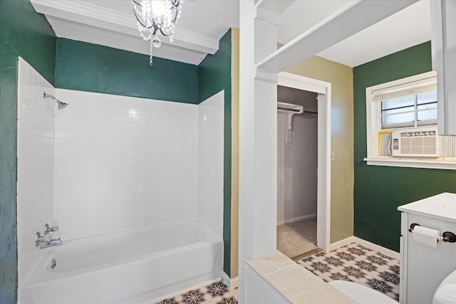 bathroom featuring cooling unit, vanity, tiled shower / bath, and an inviting chandelier