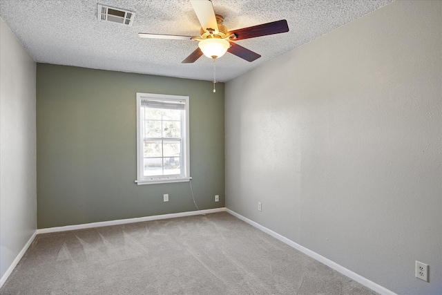 carpeted empty room with ceiling fan and a textured ceiling