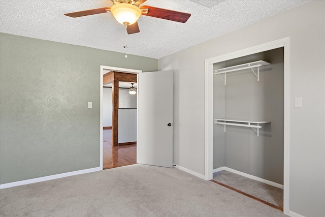 unfurnished bedroom with ceiling fan, carpet, a closet, and a textured ceiling