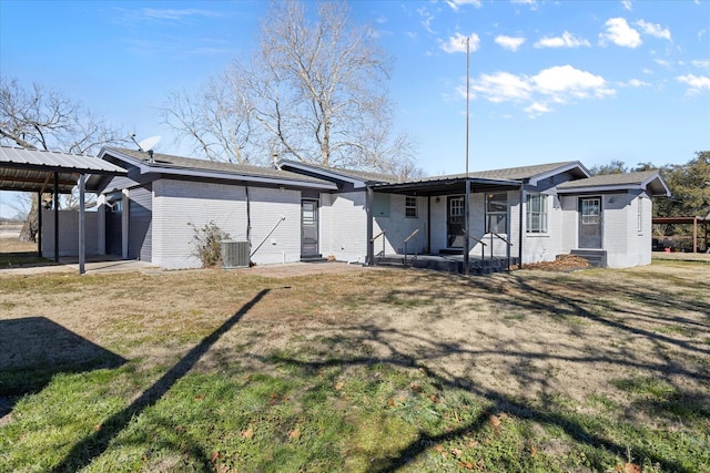 back of property featuring a carport, central AC, and a lawn