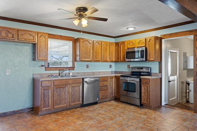 kitchen featuring sink, ceiling fan, appliances with stainless steel finishes, ornamental molding, and a textured ceiling