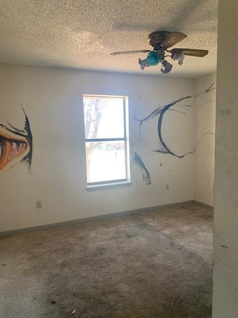 empty room featuring ceiling fan, a textured ceiling, and carpet