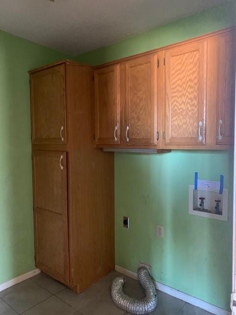 clothes washing area featuring electric dryer hookup, hookup for a washing machine, cabinets, and light tile patterned flooring