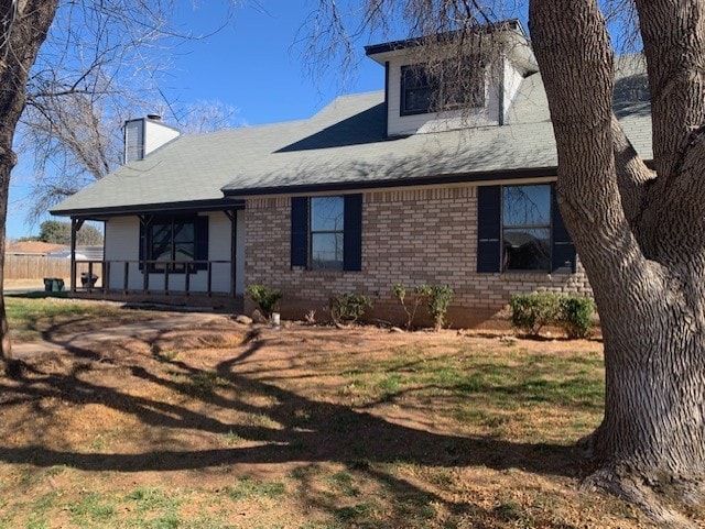 view of front of house with covered porch and a front lawn