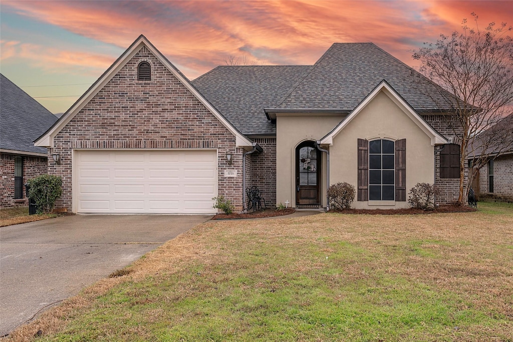 view of front of home with a yard and a garage