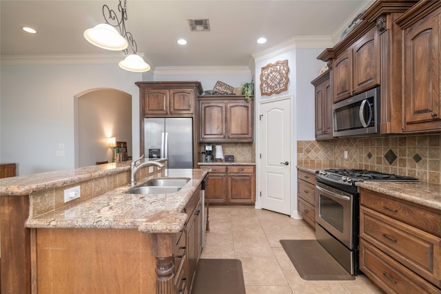 kitchen with an island with sink, appliances with stainless steel finishes, sink, and crown molding