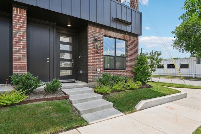 property entrance featuring a lawn