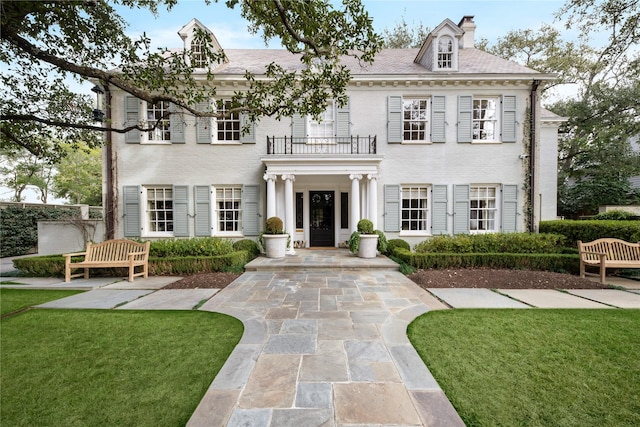 view of front of property with a front lawn and a balcony