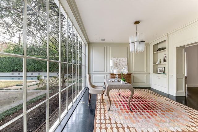 sunroom / solarium featuring a healthy amount of sunlight and a notable chandelier