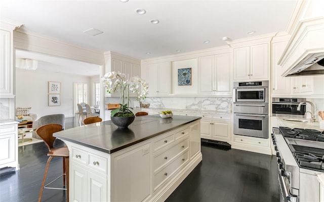 kitchen with a kitchen island, sink, dark hardwood / wood-style floors, and decorative backsplash