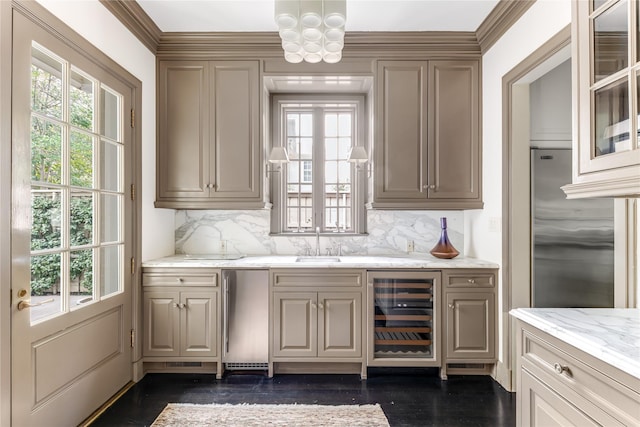 bar with light stone counters, wine cooler, a wealth of natural light, and stainless steel fridge