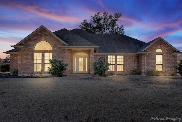 view of front of home featuring french doors and a yard