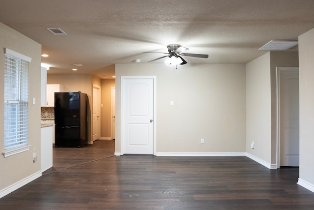 unfurnished living room with ceiling fan, a textured ceiling, and dark hardwood / wood-style flooring