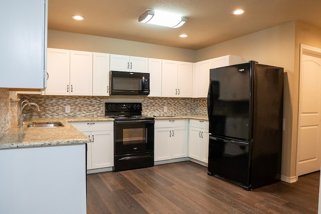 kitchen featuring sink, white cabinetry, light stone counters, tasteful backsplash, and black appliances