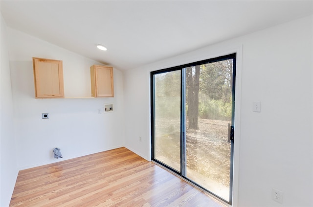 doorway featuring lofted ceiling and light wood-type flooring