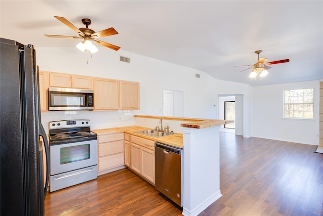 kitchen with sink, dark wood-type flooring, stainless steel appliances, and kitchen peninsula