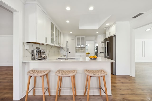 kitchen featuring white cabinetry, sink, tasteful backsplash, and kitchen peninsula