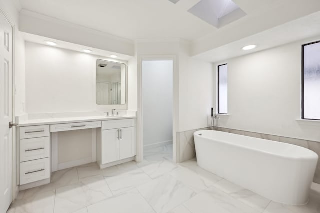 bathroom with vanity, crown molding, a wealth of natural light, and a bathing tub