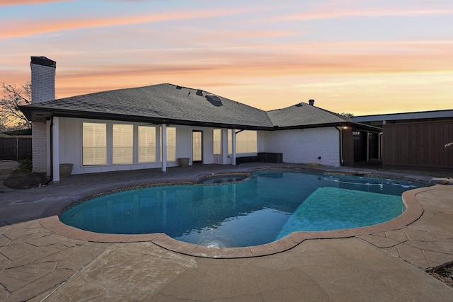 pool at dusk with a patio