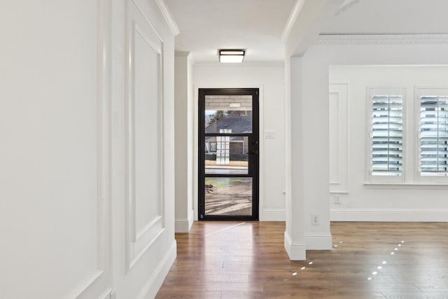 doorway to outside with ornamental molding and hardwood / wood-style floors