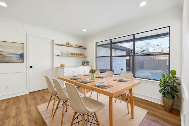 dining area featuring crown molding, plenty of natural light, and hardwood / wood-style floors