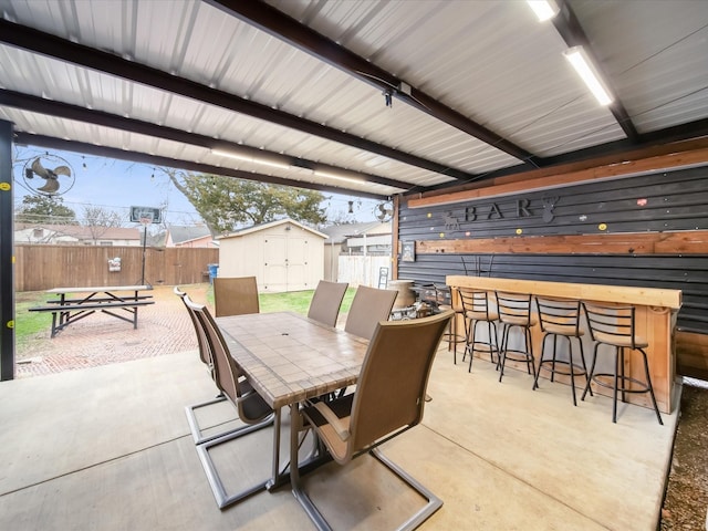 view of patio with a storage unit and a bar