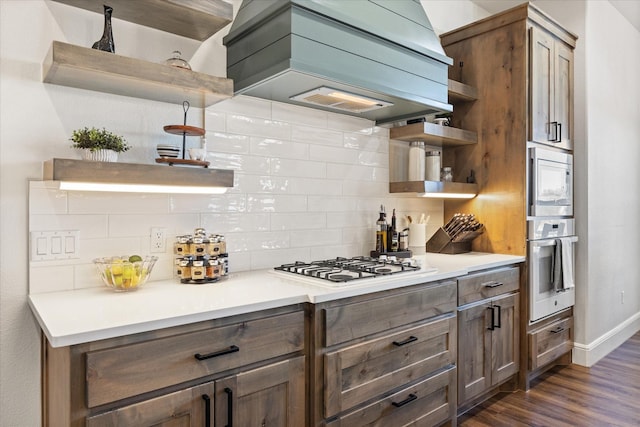 kitchen featuring white appliances, dark hardwood / wood-style flooring, custom exhaust hood, and backsplash