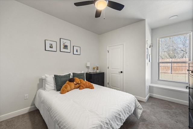 bedroom featuring multiple windows, dark carpet, and ceiling fan