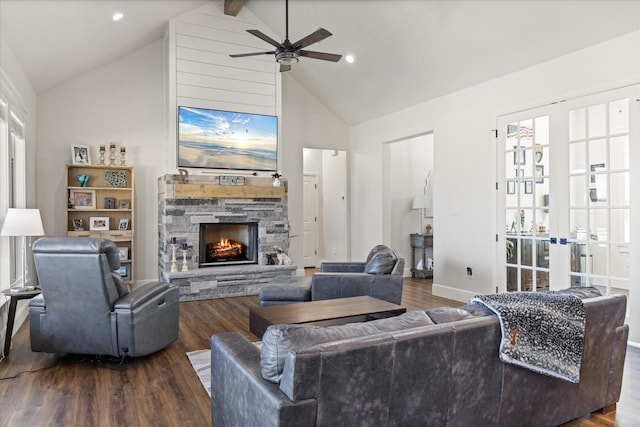 living room featuring a stone fireplace, a wealth of natural light, hardwood / wood-style floors, and vaulted ceiling with beams