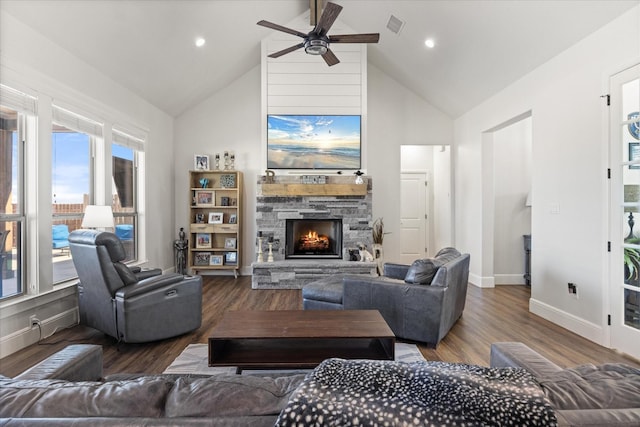 living room with wood-type flooring, a stone fireplace, high vaulted ceiling, and ceiling fan