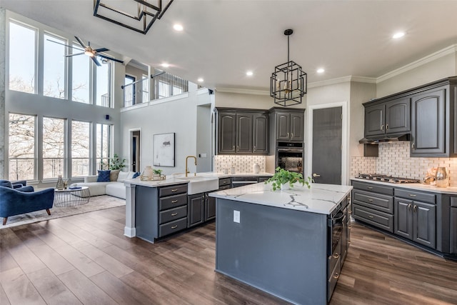 kitchen with tasteful backsplash, appliances with stainless steel finishes, a center island, and sink