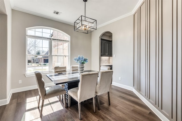 dining space featuring ornamental molding, dark hardwood / wood-style flooring, and a notable chandelier