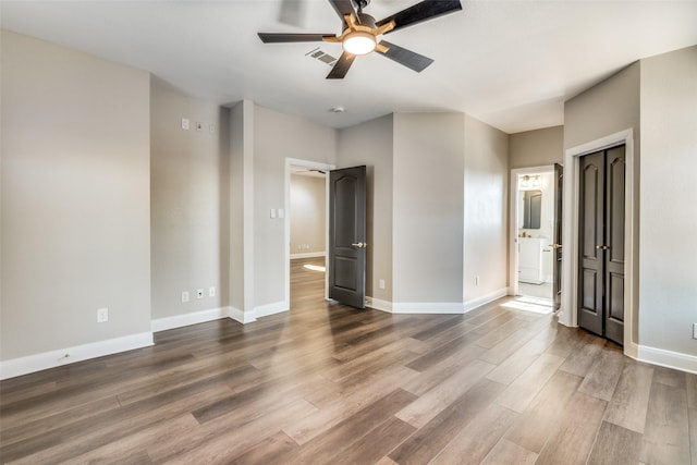 unfurnished bedroom with hardwood / wood-style flooring, ceiling fan, and ensuite bathroom