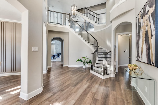 entrance foyer featuring a notable chandelier, hardwood / wood-style flooring, and a high ceiling