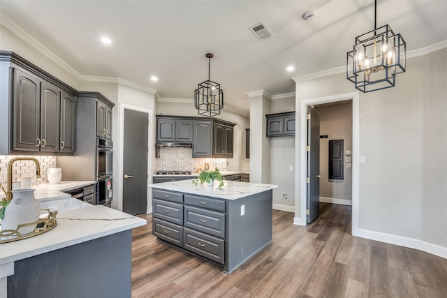 kitchen featuring gray cabinetry, decorative light fixtures, a center island, dark hardwood / wood-style floors, and decorative backsplash