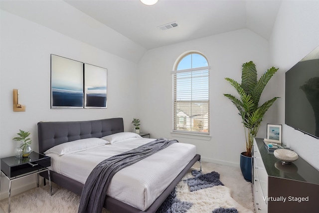 empty room featuring lofted ceiling, baseboards, visible vents, and light colored carpet